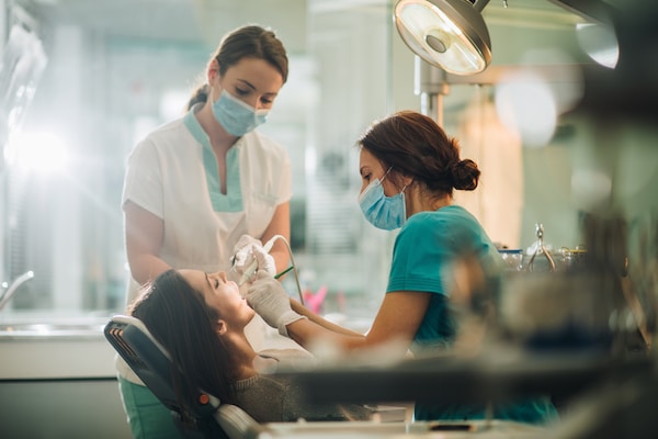 Assistente de Medicina Dentária em trabalho de clínica a quatro mãos