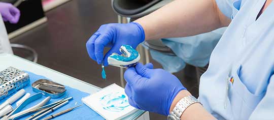 Detalhes de prótese dentária em laboratório — processo de confecção e acabamento